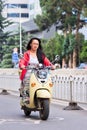 Pretty gril on a red retro style e-bike, Kunming, China