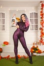 Pretty halloween woman in tight tiger jumpsuit ready to celebrate and waiting for friends for a party outdoor