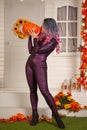 Pretty halloween woman in tight tiger jumpsuit ready to celebrate and waiting for friends for a party outdoor