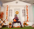 Pretty halloween woman in tight tiger jumpsuit ready to celebrate and waiting for friends for a party outdoor