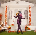 Pretty halloween woman in tight tiger jumpsuit ready to celebrate and waiting for friends for a party outdoor