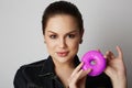 Pretty handsome girl holding hand colorful donuts against her face over white background. Attractive young woman with