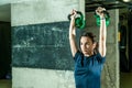 Pretty and handsome young girl holding two kettle bells in her hands for strength and conditioning fitness workout in the gym, spo Royalty Free Stock Photo