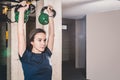 Pretty and handsome young girl holding two kettle bells in her hands for strength and conditioning fitness workout in the gym, spo