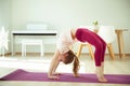 Pretty happy child girl making yoga exercises at home during coronavirus quarantine