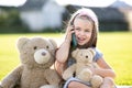 Pretty happy child girl talking on mobile phone smiling outdoors in summer Royalty Free Stock Photo