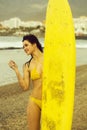 Pretty happy girl surfer with yellow surfboard Royalty Free Stock Photo