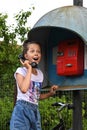 pretty happy girl is talking on a payphone on street. Emotions of admiration, surprise and joy. Royalty Free Stock Photo