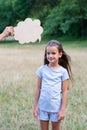 Pretty happy smiling thinking little girl posing summer nature outdoor with cloud of thoughts like in comic book. Kid`s portrai