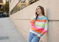 Attractive young teenager woman talking and chatting on her smart phone outside in an European city Royalty Free Stock Photo
