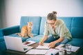 Pretty happy  young woman work home using laptop with her cat at sitting on the coach. Student freelancer lifestyle Royalty Free Stock Photo