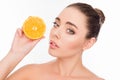 Pretty healthy girl holding half of orange near her face Royalty Free Stock Photo