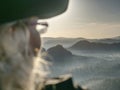 Pretty hiker backpacker sitting on peak edge and enjoying view