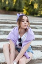 Pretty hipster girl dressed in trendy casual clothes with denim shorts, purple sweatshirt and white tee shirt with bandana Royalty Free Stock Photo