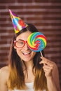 Pretty hipster with party hat and lollipop Royalty Free Stock Photo