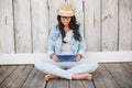 Pretty hipster sitting on ground with tablet