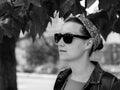 Pretty hipster woman in sunglasses, bandana, denim jacket on nature background black and white street photo. Monochrome Royalty Free Stock Photo