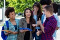 Pretty hispanic female student learning with group of latin and african american young adults Royalty Free Stock Photo