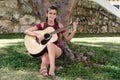 Pretty hispanic teenage girl playing an acoustic guitar Royalty Free Stock Photo