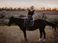 Pretty horsewoman sitting on horse on nature background. Concept of love, friendship, farm animals Royalty Free Stock Photo