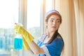 Pretty housemaid cleaning a window.