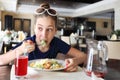 Pretty hungry girl with sunglasses eats salad in Royalty Free Stock Photo