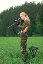 Pretty hunter girl aiming with hunting rifle and ready to shoot. Carbine on the shoulder