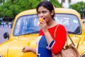 Pretty Indian/asian young girl eating Ice Cream in cone, standing near ice cream shop or taxi Royalty Free Stock Photo