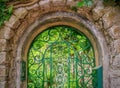 Pretty iron gate leading to a green summer garden.