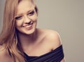 Pretty joyful toothy laughing young woman with fair blond long hair in casual dress looking with happy. Studio shot of good Royalty Free Stock Photo