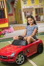 Pretty kid sitting in toy car at play center. Royalty Free Stock Photo