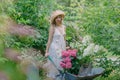 Pretty lady a beautiful gardener with wheelbarrow and flower pots with hydrangea seedlings Royalty Free Stock Photo