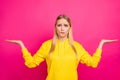 Pretty lady biting lips not sure what to buy wear yellow hoodie pullover isolated pink background Royalty Free Stock Photo