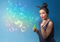 Pretty lady blowing colorful bubbles on blue background Royalty Free Stock Photo