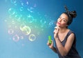 Pretty lady blowing colorful bubbles on blue background Royalty Free Stock Photo