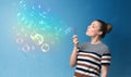 Pretty lady blowing colorful bubbles on blue background Royalty Free Stock Photo