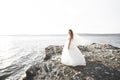 Pretty lady, bride posing in a wedding dress near sea on sunset Royalty Free Stock Photo