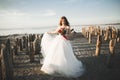 Pretty lady, bride posing in a wedding dress near sea on sunset Royalty Free Stock Photo