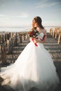 Pretty lady, bride posing in a wedding dress near sea on sunset Royalty Free Stock Photo