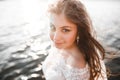 Pretty lady, bride posing in a wedding dress near sea on sunset Royalty Free Stock Photo