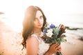 Pretty lady, bride posing in a wedding dress near sea on sunset Royalty Free Stock Photo