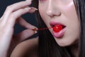 Pretty lady with fleshy lips, biting a sweet cherry Royalty Free Stock Photo