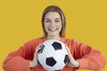 Portrait of a happy cheerful young student girl holding a soccer ball and smiling Royalty Free Stock Photo