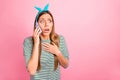 Pretty lady speaking over telephone not believe bad happening wear striped pullover isolated pink background