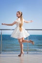 A pretty lady walking on a terrace. A smiling female with long hair on a bright sky background. Royalty Free Stock Photo