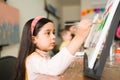 Pretty latin girl finishing her painting in an art school for children Royalty Free Stock Photo