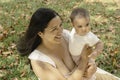 Pretty latin mother with baby in arms enjoying outdoors together