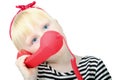 Pretty little blond girl with a red retro phone, isolated on a Royalty Free Stock Photo