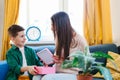 Pretty little boy presenting gift to happy mother on Mothers Day Royalty Free Stock Photo