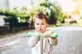 Pretty little boy riding scooter outdoor on the street Royalty Free Stock Photo